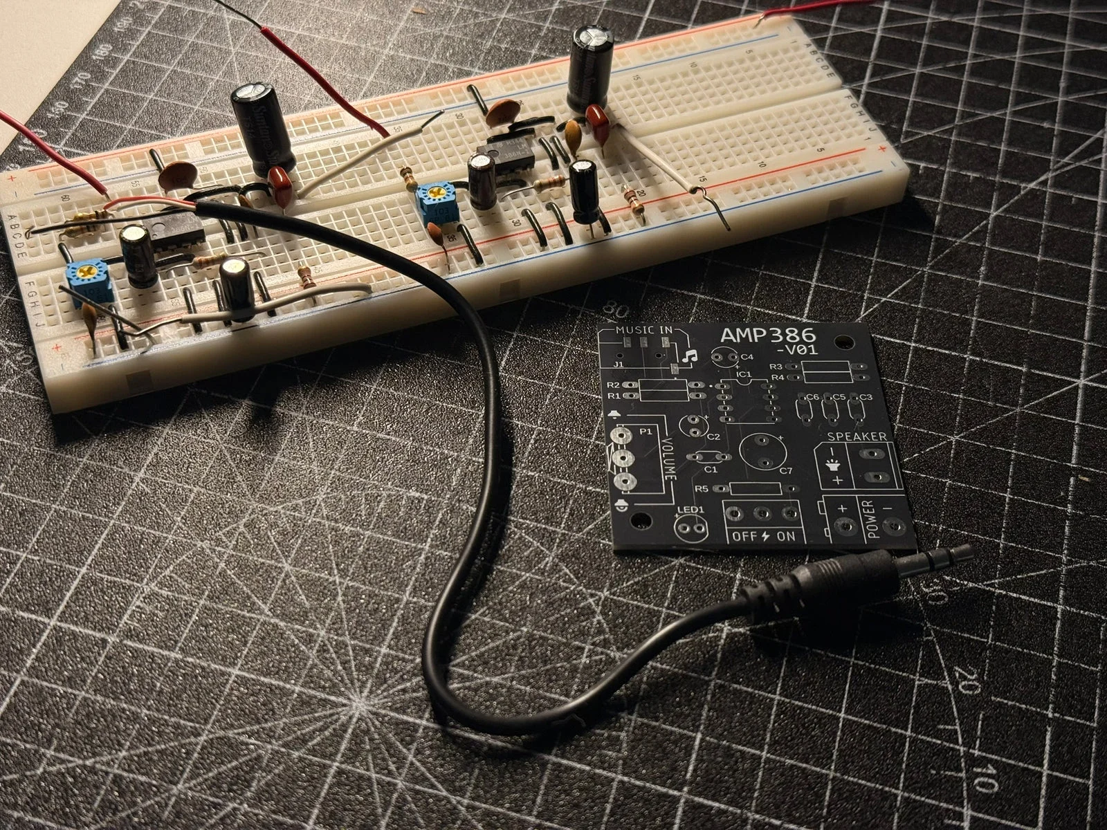 Prototipo de amplificador con LM386 en protoboard y su PCB sobre la mesa de trabajo de Bruno
